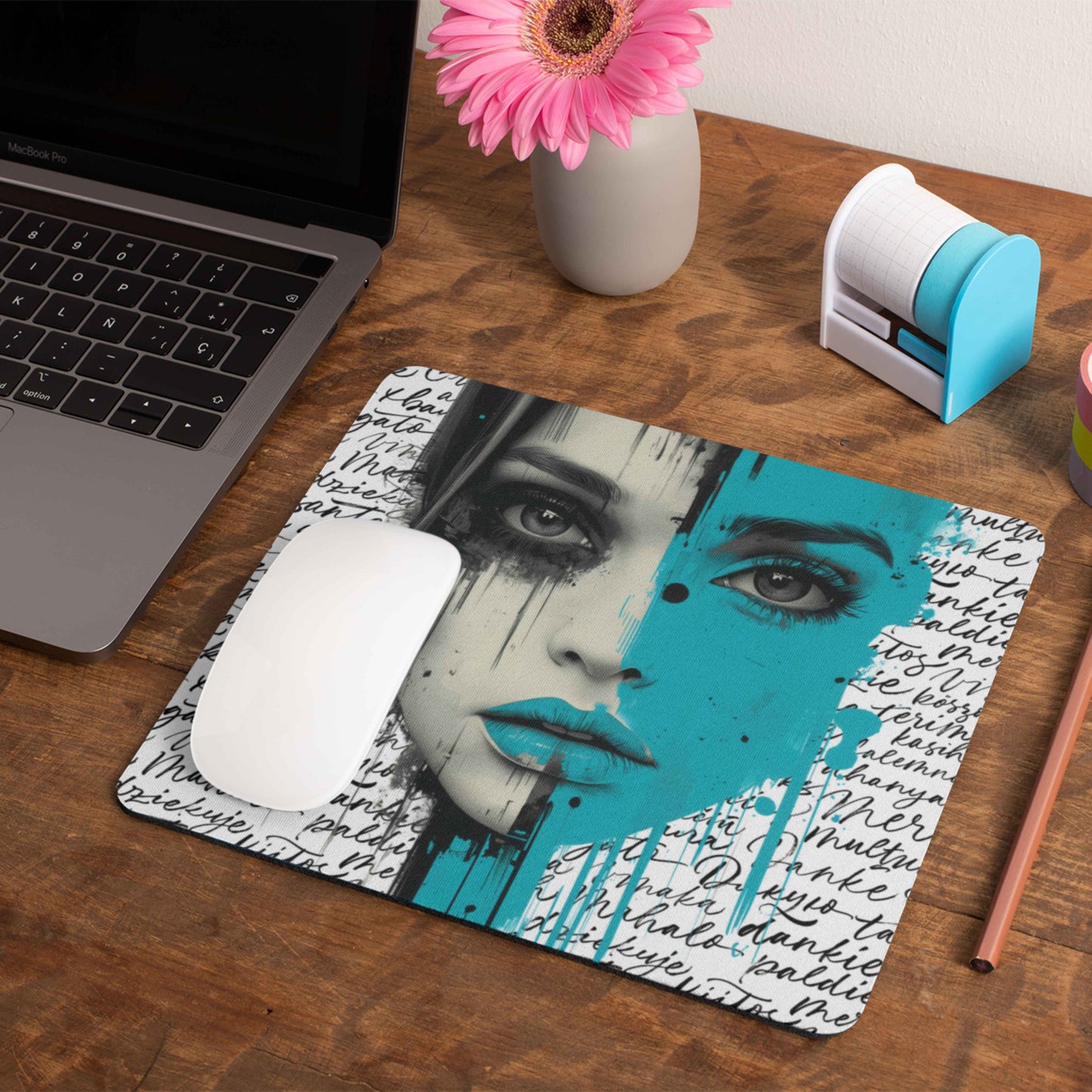 Get ready to celebrate International Women's Day with this fierce mouse pad which features a striking design of a woman's face, with one half in bold, vibrant teal, framed by a collection of cursive words in different languages.
