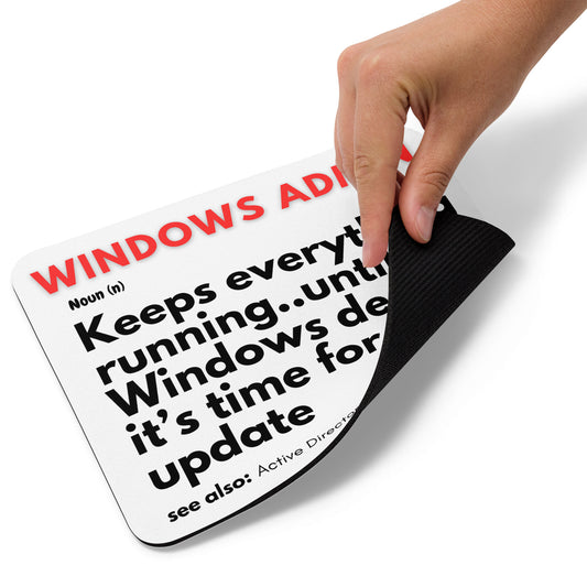 White mouse pad with a soft polyester surface and rubber base featuring a fun definition of what a Windows Administrator does - Keeps everything running until Windows decides it's time for an update.